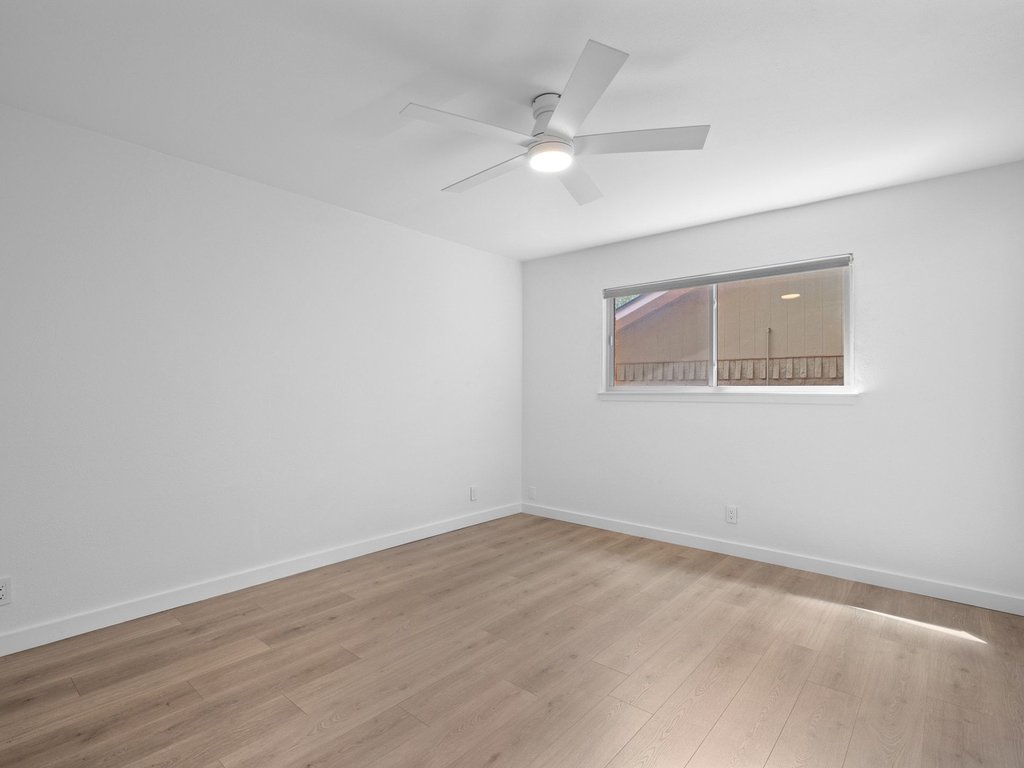 6902 Meadow Run Austin, TX 78745 - Photo 14 of 33 a view of an empty room with wooden floor and a ceiling fan