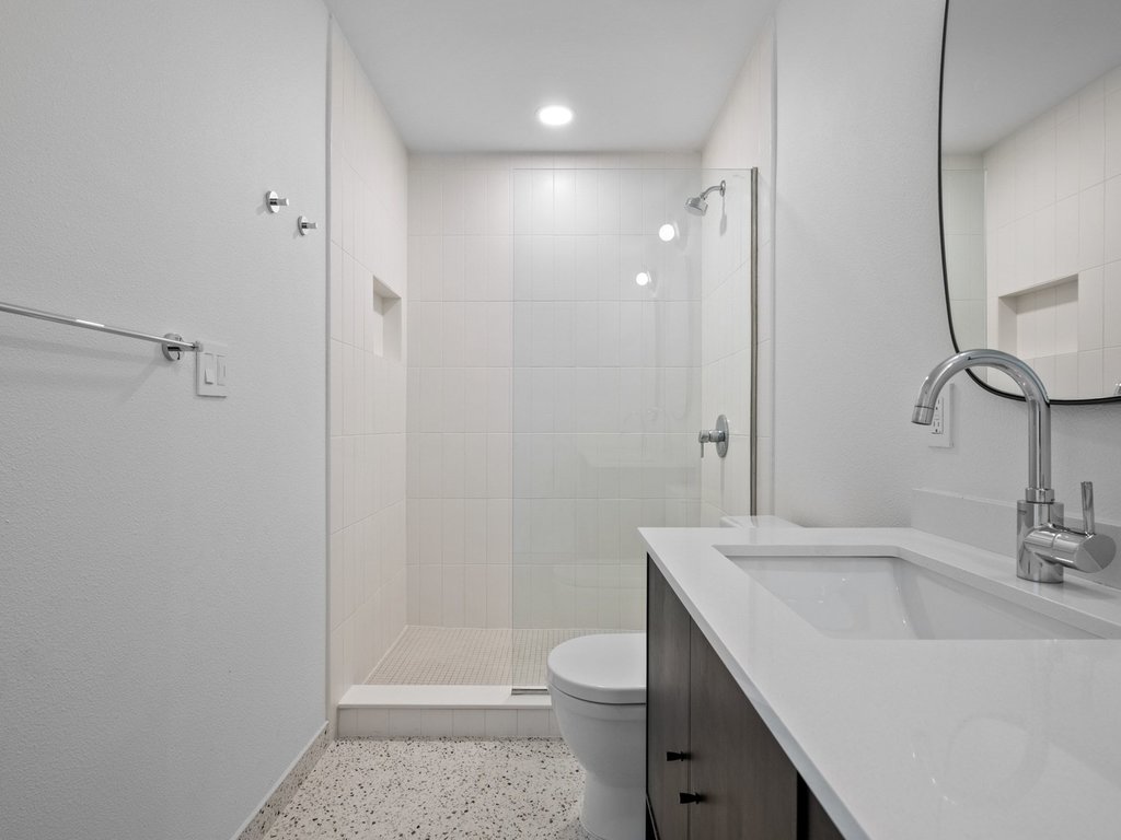 6902 Meadow Run Austin, TX 78745 - Photo 16 of 33 a bathroom with a sink a toilet and shower