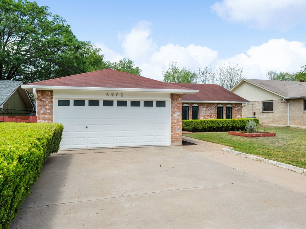 6902 Meadow Run Austin, TX 78745 - Photo 32 of 33 a front view of a house with a yard and potted plants