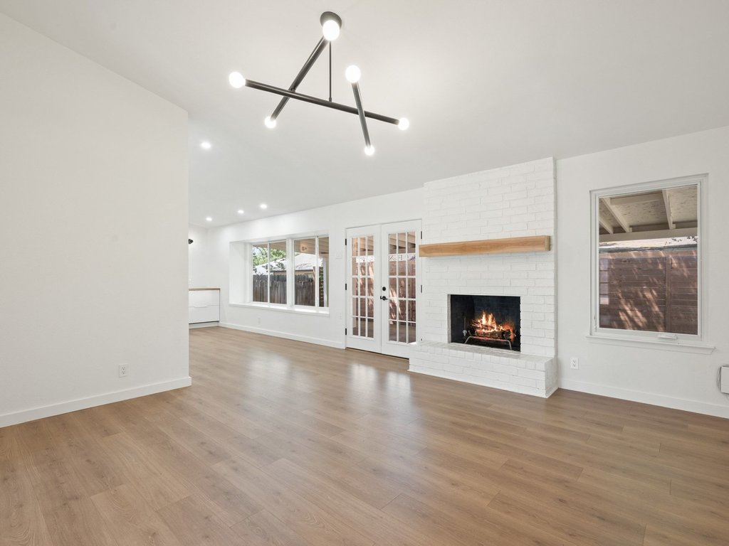 6902 Meadow Run Austin, TX 78745 - Photo 6 of 33 a view of an empty room with a fireplace and a window