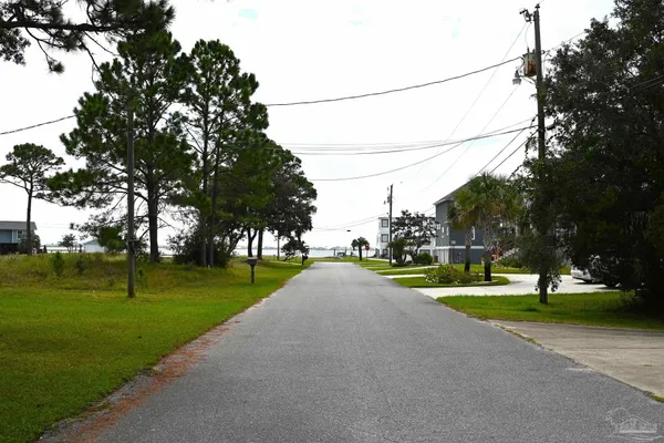 a view of a street with a big yard