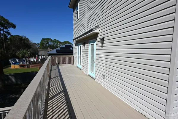 a view of balcony with wooden floor and trees in the back
