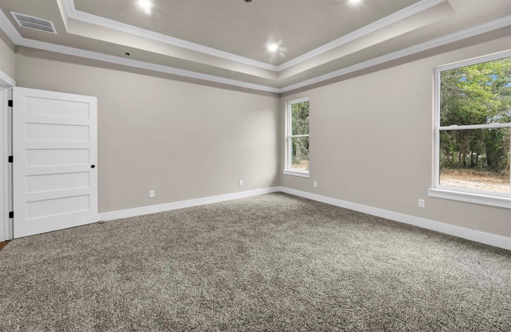 2016 Forest Bridge Azle, TX 76020 - Photo 15 of 16 Carpeted spare room featuring a raised ceiling and crown molding