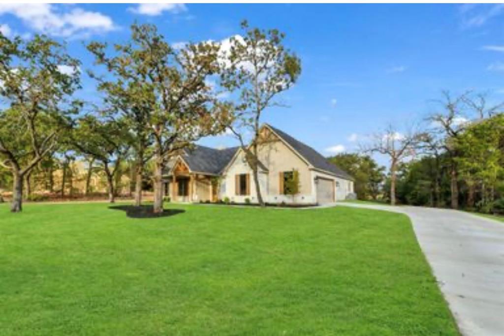 2016 Forest Bridge Azle, TX 76020 - Photo 4 of 16 View of front of house with a front yard, driveway, and an attached garage