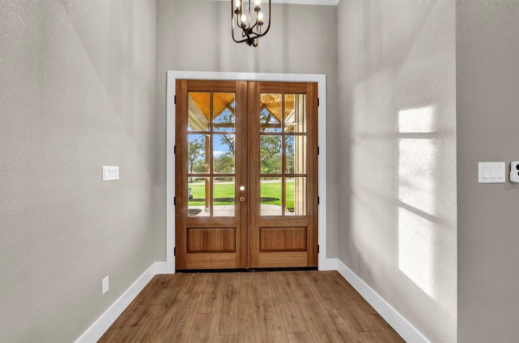 2016 Forest Bridge Azle, TX 76020 - Photo 6 of 16 Entryway with a textured wall, wood finished floors, a chandelier, and french doors
