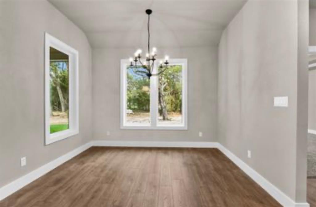 2016 Forest Bridge Azle, TX 76020 - Photo 10 of 16 Unfurnished dining area featuring dark wood-type flooring and a chandelier