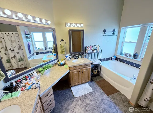 a bathroom with a bathtub sink and mirror