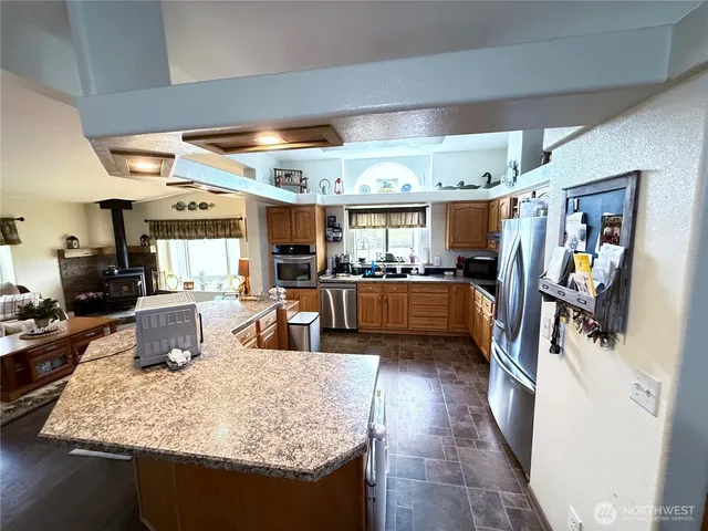 a kitchen with stainless steel appliances granite countertop sink stove and refrigerator