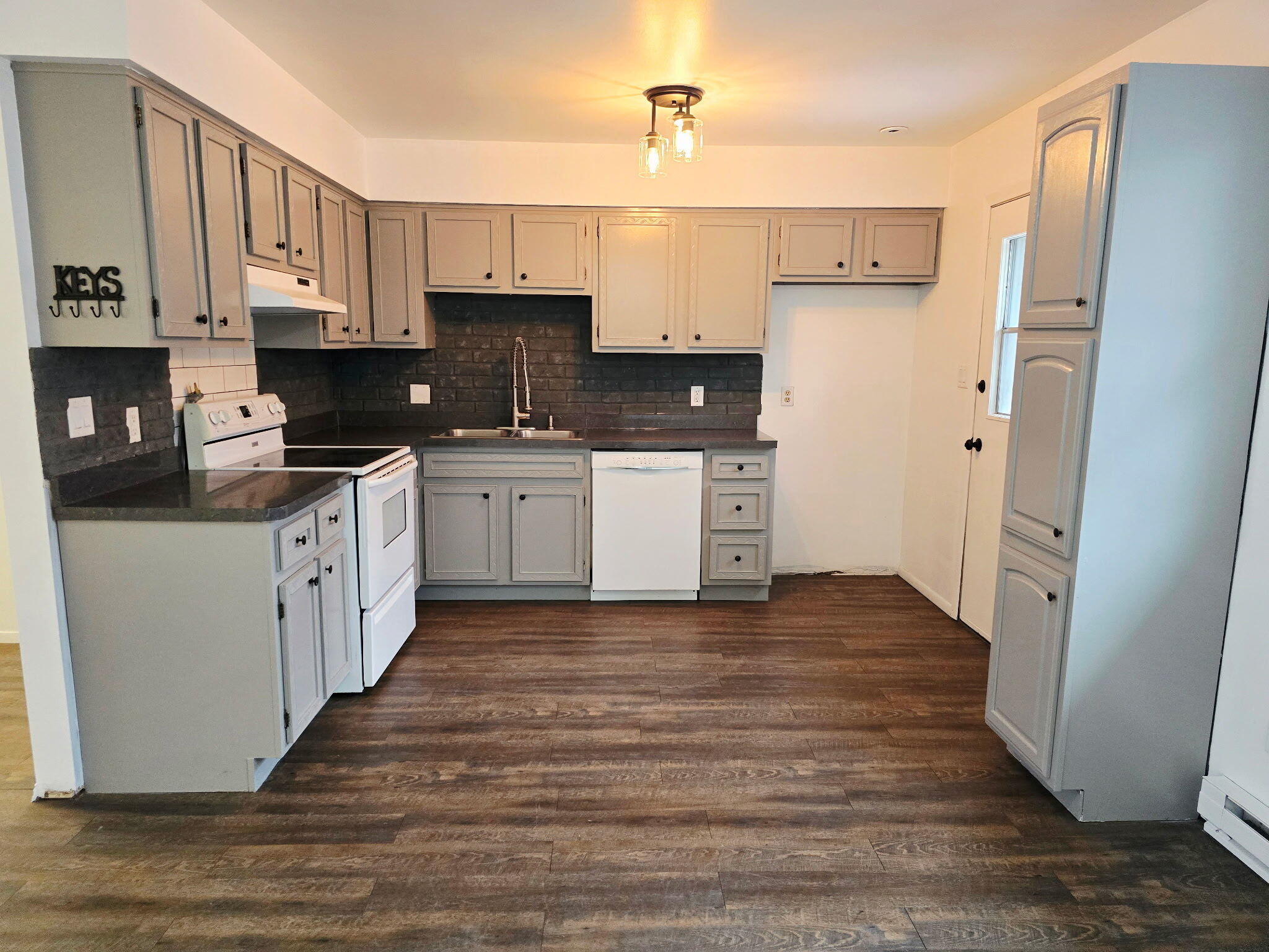 11535 Sandhill Trail Demotte, IN 46310 - Photo 6 of 31 a kitchen with stainless steel appliances granite countertop a refrigerator a stove top oven a sink and dishwasher with wooden floor