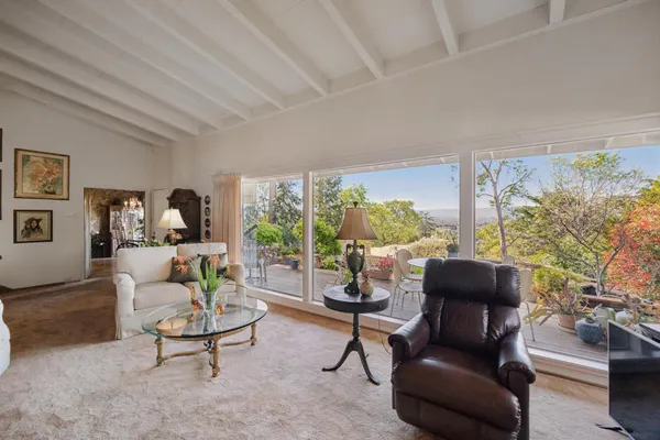 a living room with furniture fireplace and a large window
