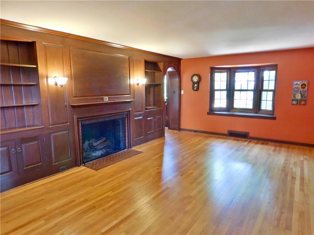 31 Roxbury Road Pittsburgh, PA 15221 - Photo 3 of 25 Very generous 22 foot living room. It has a wood paneled wall with built ins and a log burning fireplace.