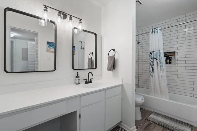 a bathroom with a double vanity sink mirror and bathtub
