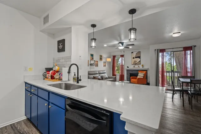 a view of a kitchen with kitchen island a sink wooden floor and living room view