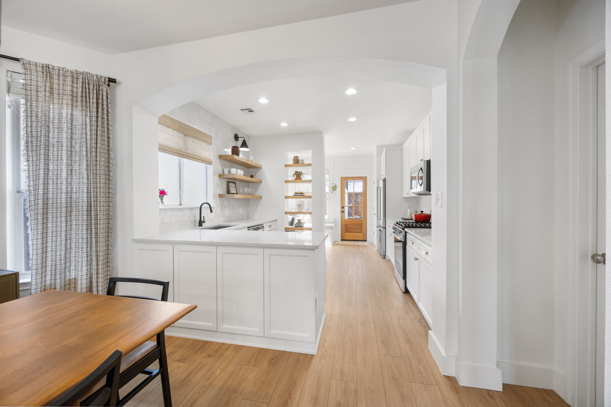 2510 Thornton Road Austin, TX 78704 - Photo 7 of 40 a kitchen with white cabinets and wooden floor