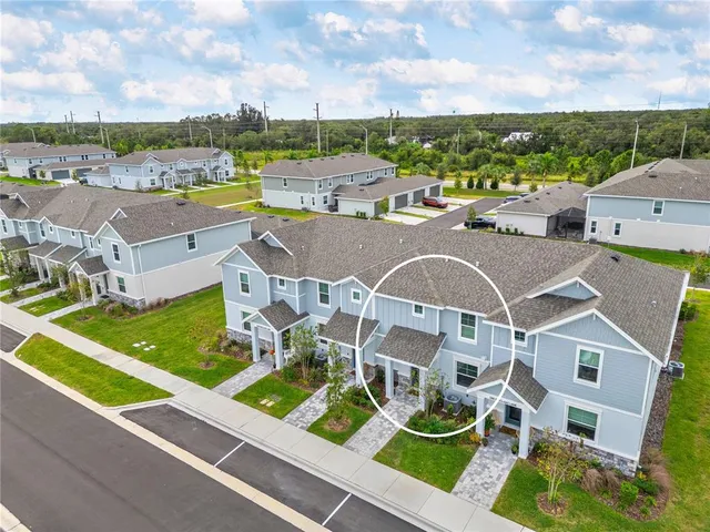 an aerial view of residential houses with outdoor space and river