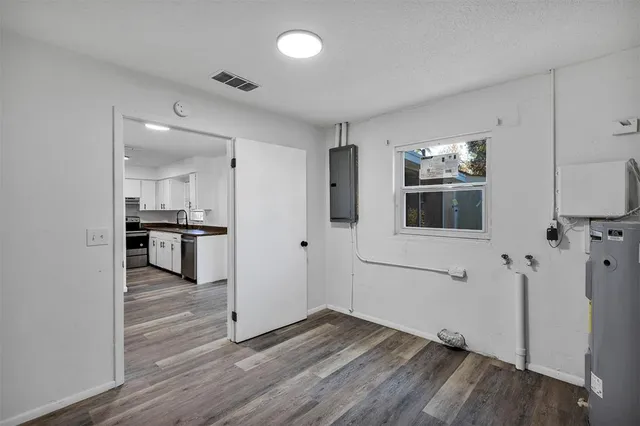 a view of a kitchen with wooden floor and electronic appliances
