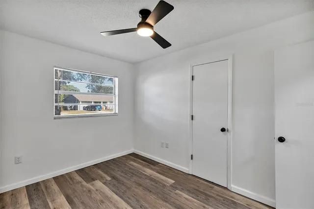 a view of empty room with wooden floor