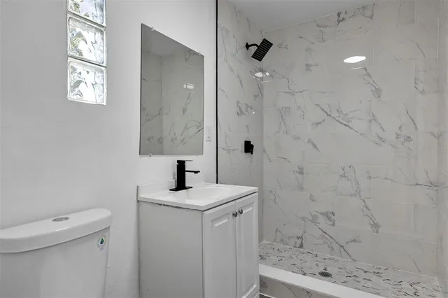 a bathroom with a sink a toilet and shower