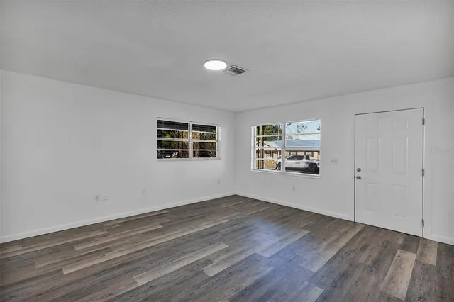 a view of a livingroom with wooden floor and window