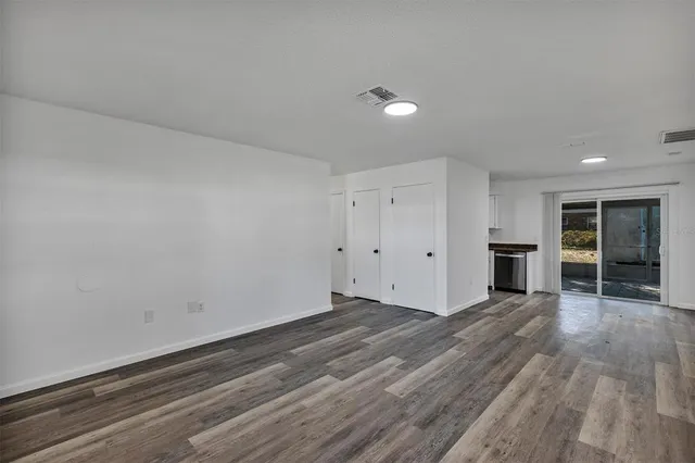 a view of empty room with wooden floor