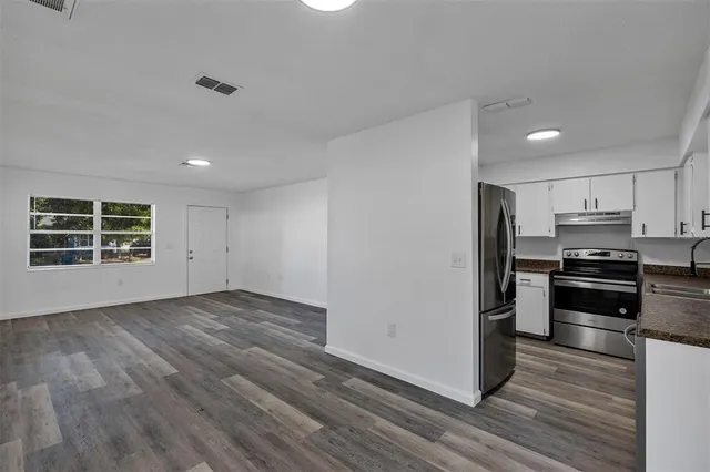 a view of a kitchen with wooden floor and electronic appliances