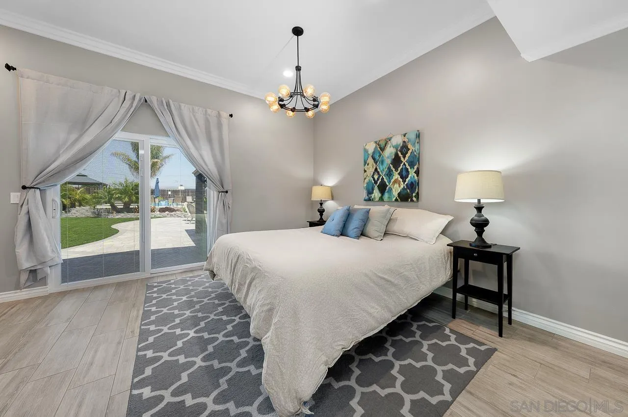 9311 Oakbourne Road Santee, CA 92071 - Photo 16 of 64 a bedroom with a bed chandelier and a window