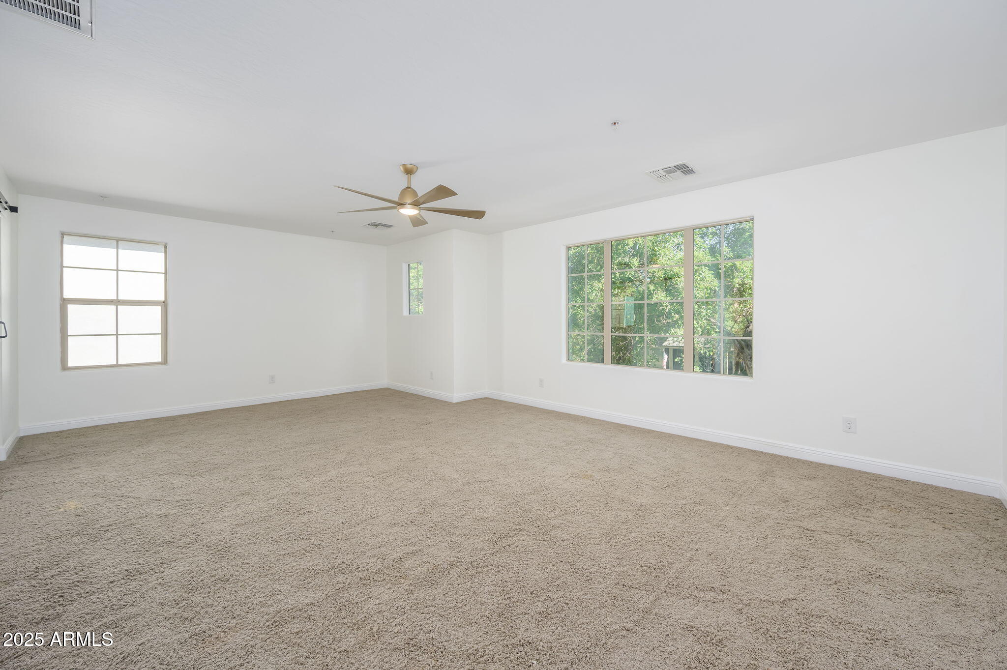 20563 West White Rock Road Buckeye, AZ 85396 - Photo 8 of 17 an empty room with windows and ceiling fan view