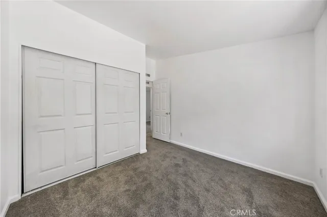 a front view of house with yard and trees in the background