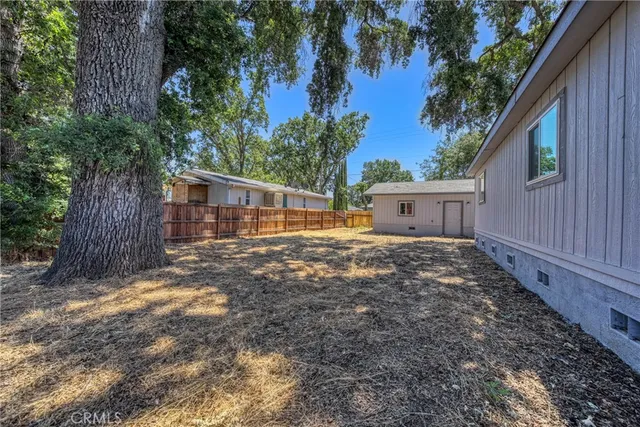 a view of a house with backyard and tree