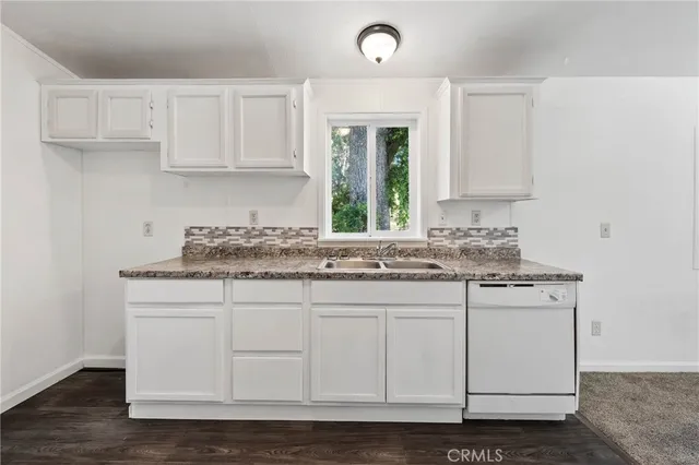 a kitchen with granite countertop white cabinets and white appliances