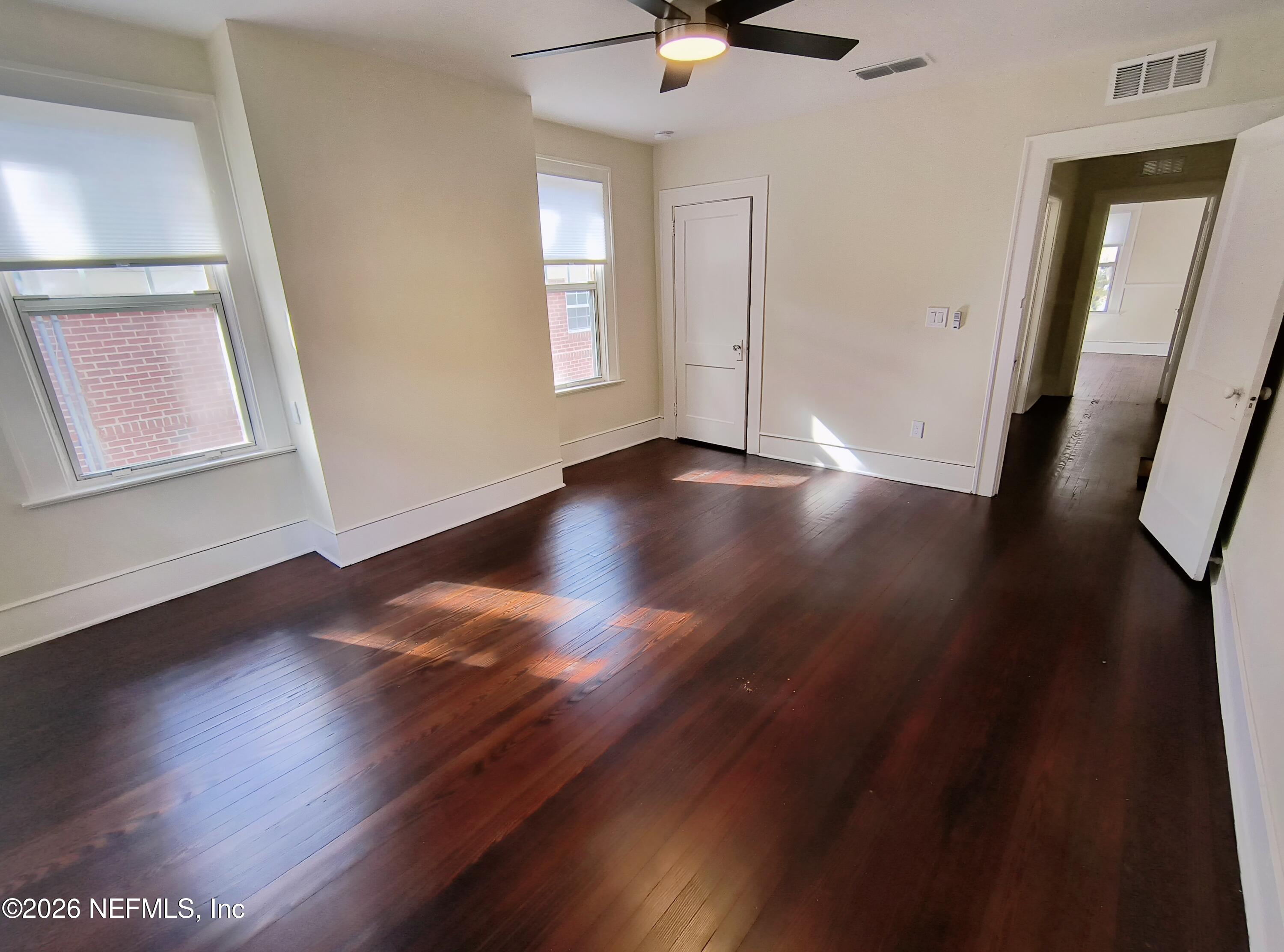 3577 Valencia Road, Unit 1 Jacksonville, FL 32205 - Photo 12 of 17 an empty room with wooden floor and windows