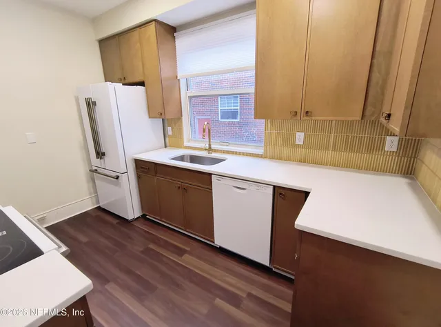 a view of a kitchen with wooden floor and electronic appliances