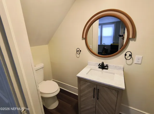 a bathroom with a sink a toilet and a mirror