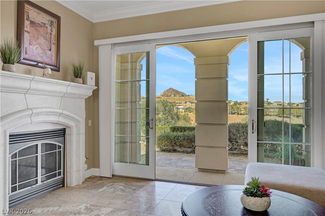10 Strada Bella Vista, Unit 101 Henderson, NV 89011 - Photo 11 of 64 Doorway to outside with crown molding and a glass covered fireplace