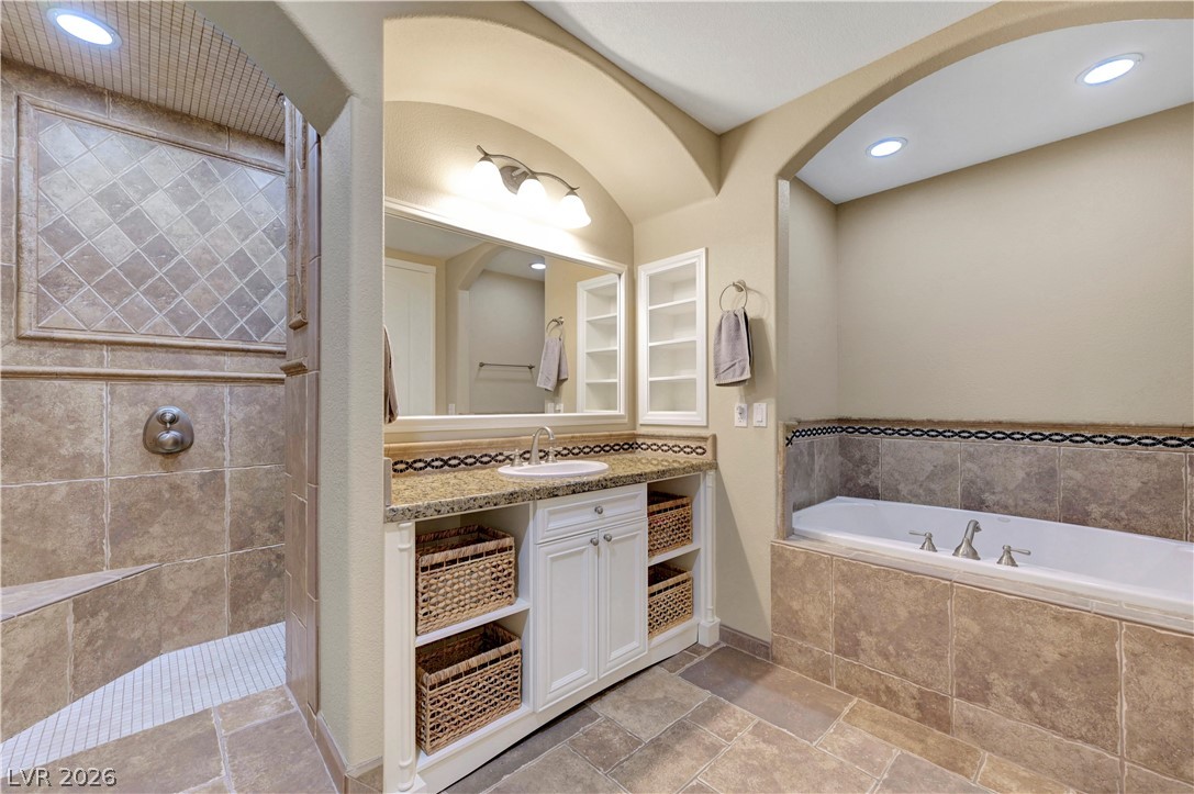 10 Strada Bella Vista, Unit 101 Henderson, NV 89011 - Photo 28 of 64 Bathroom featuring vanity, a shower stall, recessed lighting, and stone tile flooring