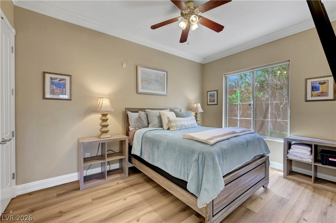 10 Strada Bella Vista, Unit 101 Henderson, NV 89011 - Photo 30 of 64 Bedroom with laminate wood finished floors, crown molding, and a ceiling fan