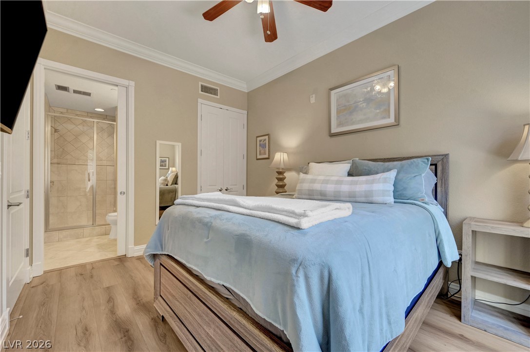 10 Strada Bella Vista, Unit 101 Henderson, NV 89011 - Photo 31 of 64 2nd Bedroom featuring light wood-type flooring, ornamental molding, ceiling fan, and connected bathroom