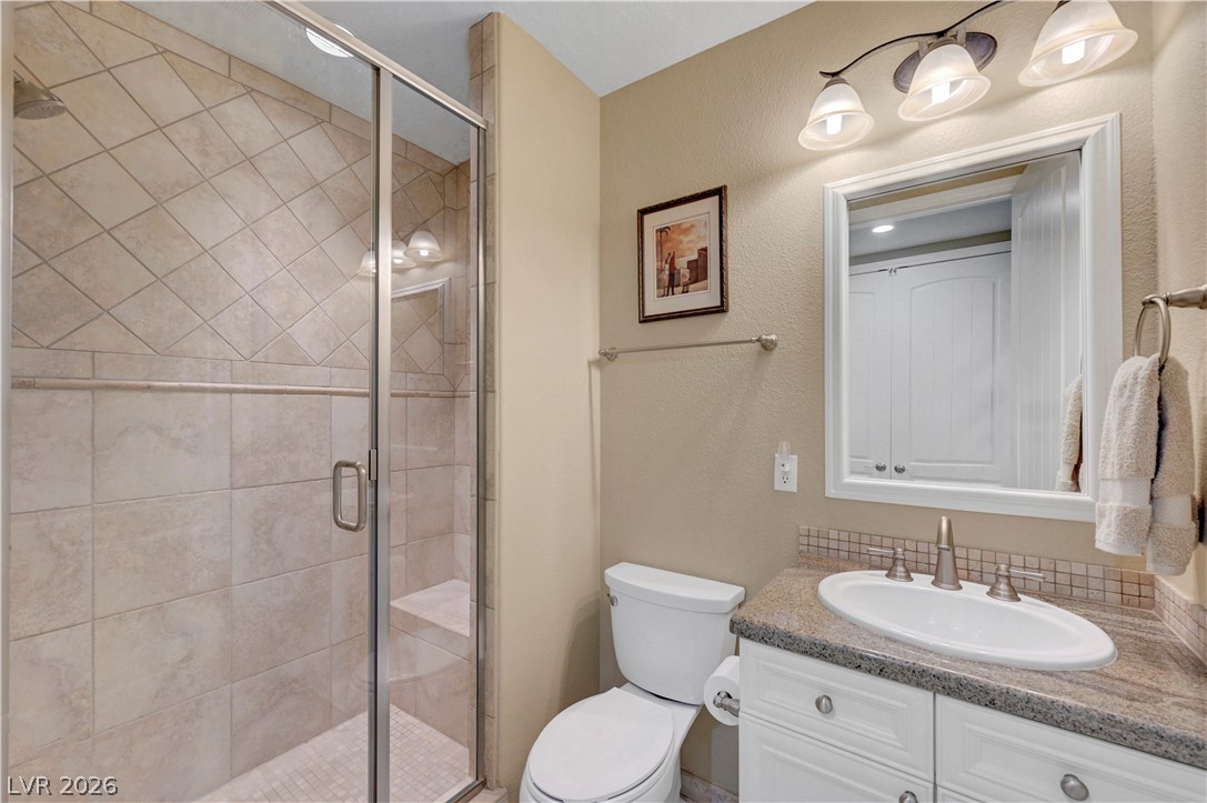 10 Strada Bella Vista, Unit 101 Henderson, NV 89011 - Photo 32 of 64 Bathroom with vanity, a shower stall, and a textured wall