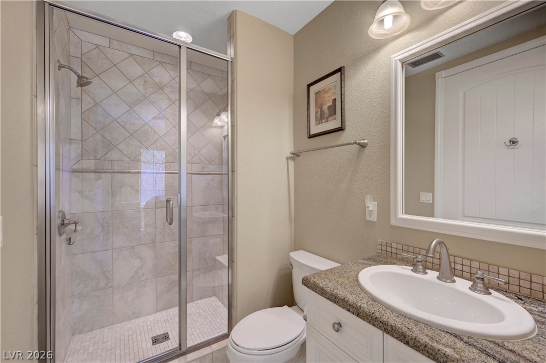 10 Strada Bella Vista, Unit 101 Henderson, NV 89011 - Photo 34 of 64 Bathroom with vanity, a shower stall, and a textured wall