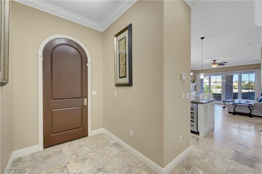 10 Strada Bella Vista, Unit 101 Henderson, NV 89011 - Photo 7 of 64 Entryway with crown molding, arched walkways, wine cooler, and ceiling fan
