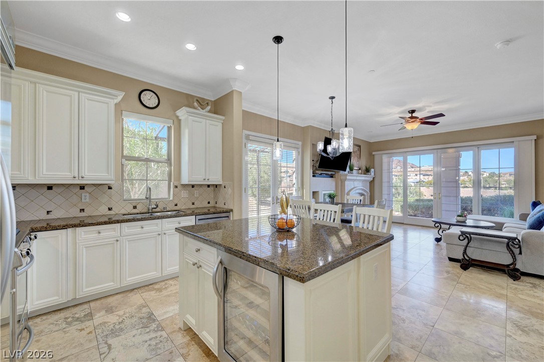 10 Strada Bella Vista, Unit 101 Henderson, NV 89011 - Photo 63 of 64 Kitchen featuring wine cooler, a center island, granite countertops, crown molding, and open floor plan