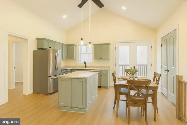 a kitchen with a table chairs refrigerator and cabinets