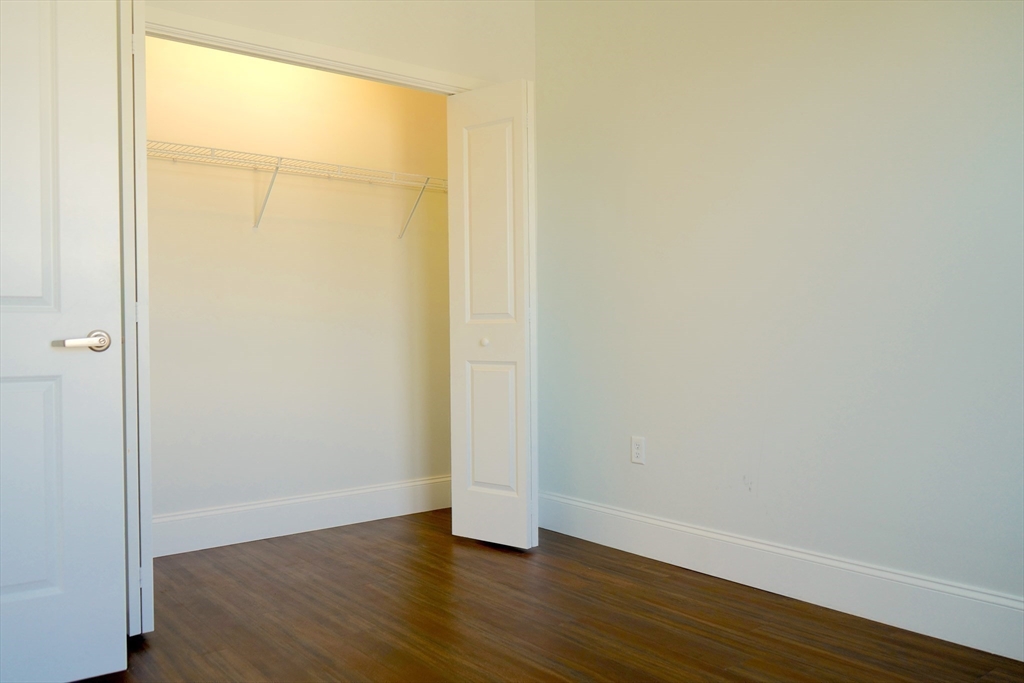 205 Maverick Street, Unit 412 Boston, MA 02128 - Photo 11 of 15 an empty room with wooden floor and a window
