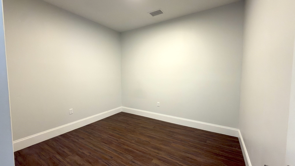 205 Maverick Street, Unit 412 Boston, MA 02128 - Photo 12 of 15 a view of an empty room with wooden floor