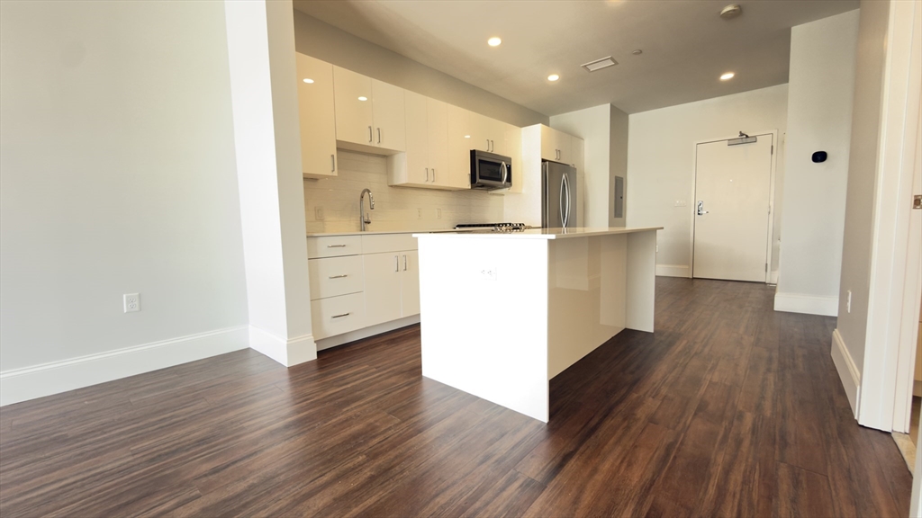 205 Maverick Street, Unit 412 Boston, MA 02128 - Photo 2 of 15 a kitchen with a refrigerator and a stove top oven