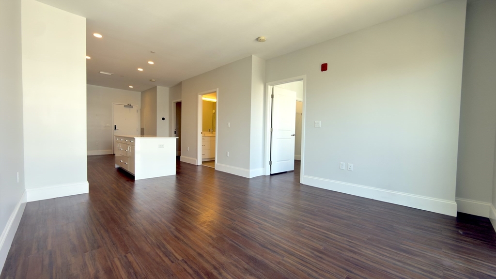 205 Maverick Street, Unit 412 Boston, MA 02128 - Photo 4 of 15 a view of an empty room with wooden floor and a window
