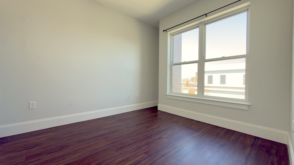 205 Maverick Street, Unit 412 Boston, MA 02128 - Photo 9 of 15 a view of an empty room with wooden floor and a window