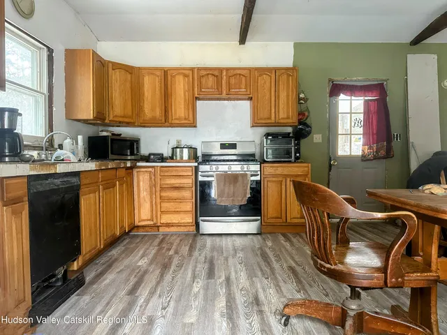a kitchen with stainless steel appliances granite countertop a stove top oven a sink dishwasher and cabinets with wooden floor