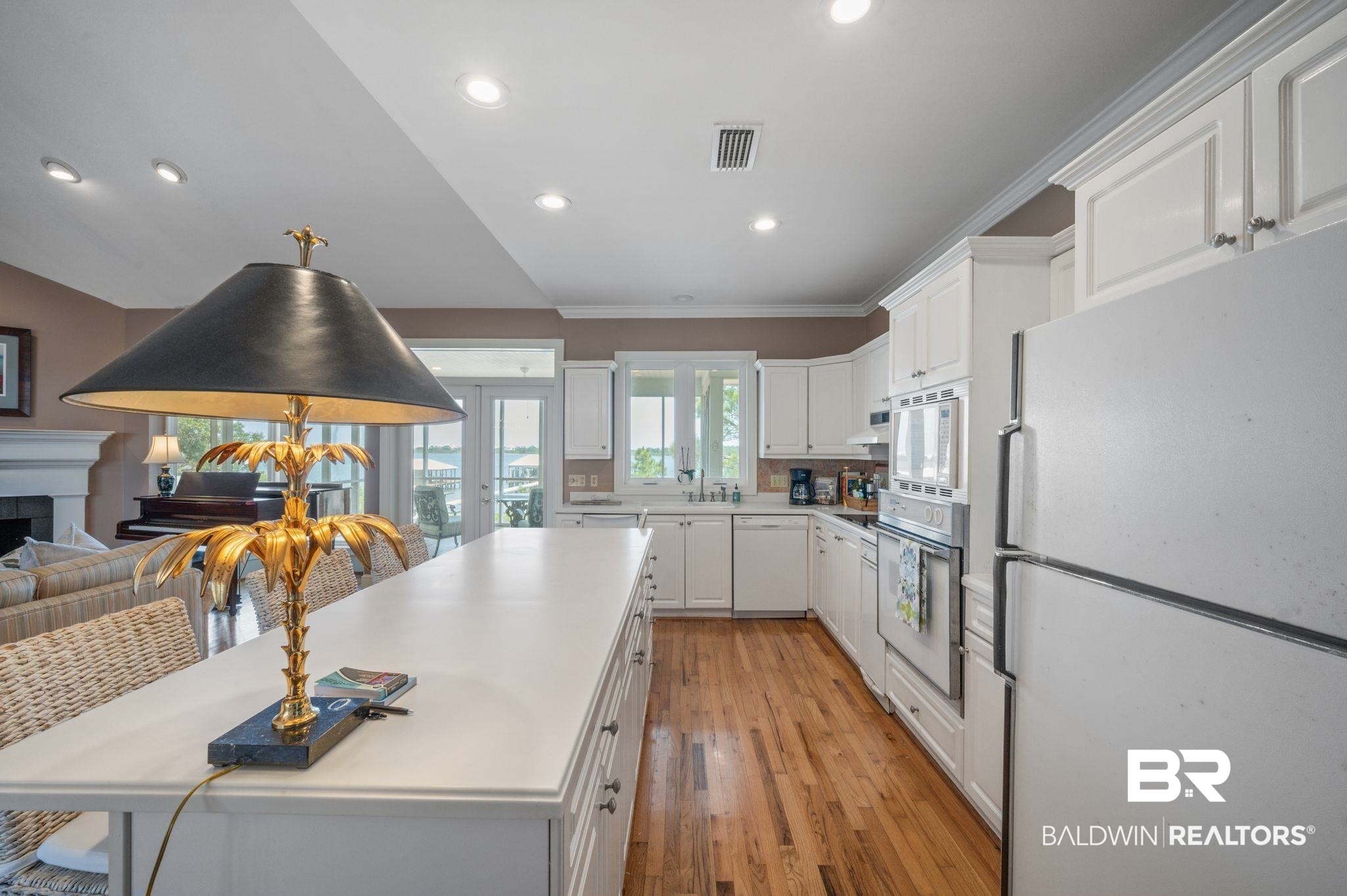 31800 River Road Orange Beach, AL 36561 - Photo 8 of 69 Kitchen featuring white cabinets, light hardwood / wood-style floors, sink, crown molding, and white appliances