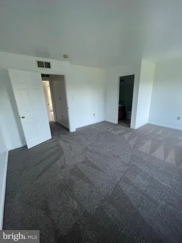 a view of a big room with closet and windows